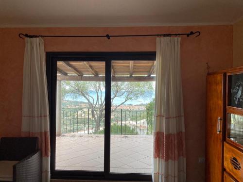 eine Glasschiebetür mit Blick auf eine Terrasse in der Unterkunft Il belvedere in Budoni