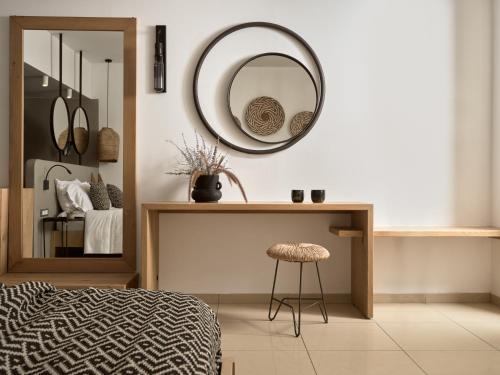 a bedroom with a mirror and a table and a stool at Seaside A Lifestyle Resort - Adults Only in Agia Pelagia