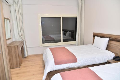 a hotel room with two beds and a window at New Lotus Hotel in Cairo