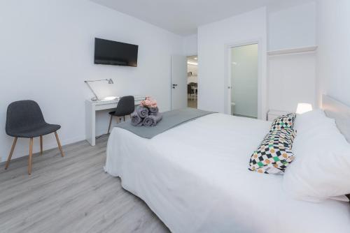een witte slaapkamer met een wit bed en een bureau bij Buena Vista House by Canarias Homelidays in Santa Brígida