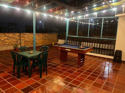 una mesa de ping pong en medio de una habitación con sillas en CASA DE LOURDES - LA CANDELARIA, en Bogotá