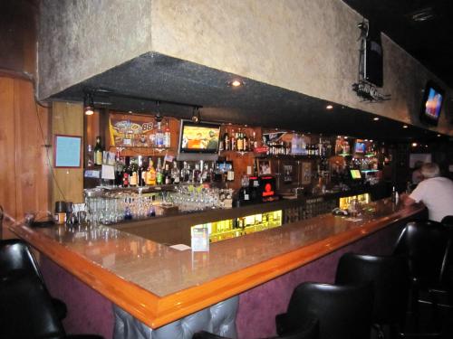 un bar en un restaurante con un hombre de pie en el bar en Travelers INN, en West Sacramento