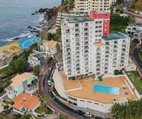 una vista aerea di un edificio vicino all'oceano di Apartamento do Mar e Lua a Funchal