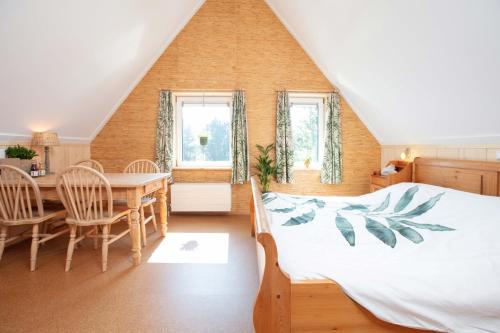 1 dormitorio con 1 cama, mesa y sillas en Vegan B&B De Groene Mus, en Wervershoof