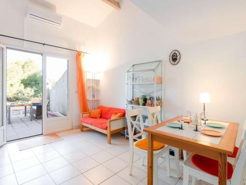 un salon avec une table et une salle à manger dans l'établissement Pavillon Climatisé 3 Pièces avec Piscine, Terrasse, Parking, et Télévision - 4 Couchages - FR-1-409-3, à Narbonne-Plage