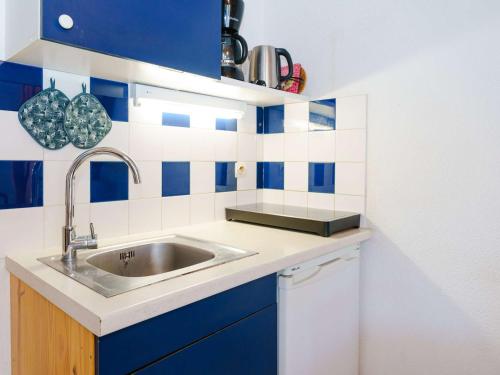 - une cuisine avec un évier et du carrelage bleu et blanc dans l'établissement Villa 2 pièces avec mezzanine, terrasse et accès piscine à Gruissan - 5 couchages - FR-1-409-9, à Gruissan