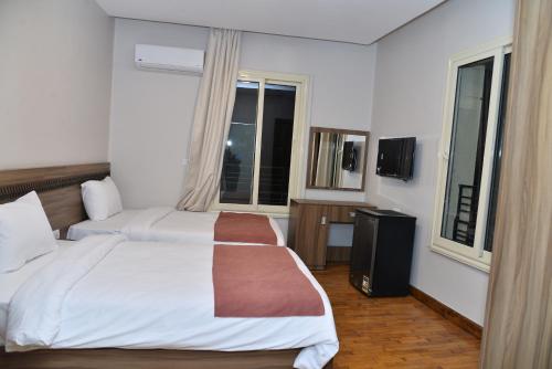 a hotel room with two beds and two windows at New Lotus Hotel in Cairo