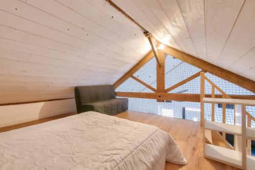 une chambre avec un lit et une chaise dans un grenier dans l'établissement Jard-sur-Mer - Tranquillité assurée, à Jard-sur-Mer