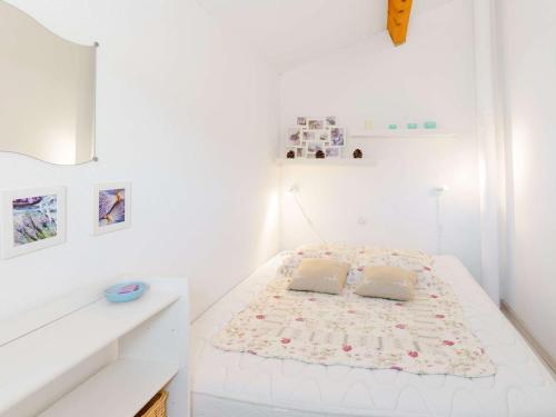Cette chambre blanche dispose d'un lit avec deux oreillers. dans l'établissement Villa 3 pièces avec piscine, terrasse et parking privé - 4 personnes, animaux acceptés - FR-1-409-20, à Gruissan