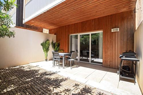 un patio avec une table, des chaises et un barbecue dans l'établissement Le Juvignacois- 2 bedrooms and large terrace !, à Juvignac