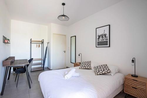 una camera con letto bianco e scrivania di Le Juvignacois- 2 bedrooms and large terrace a Juvignac