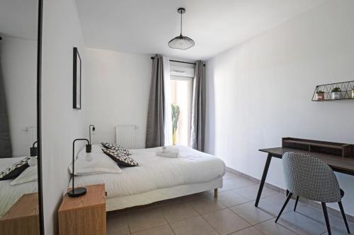 瑞維尼亞克的住宿－Le Juvignacois- 2 bedrooms and large terrace，一间卧室配有一张床、一张书桌和一个窗户。