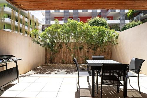 un patio avec une table et des chaises et une clôture dans l'établissement Le Juvignacois- 2 bedrooms and large terrace !, à Juvignac