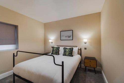een slaapkamer met een wit bed met 2 kussens bij Modern 2 Bed Ground Floor - Private Parking in Windsor