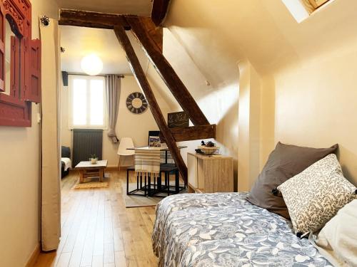 Le Nid - Chartres Cœur de ville في شارتر: غرفة نوم بسرير ومكتب في غرفة