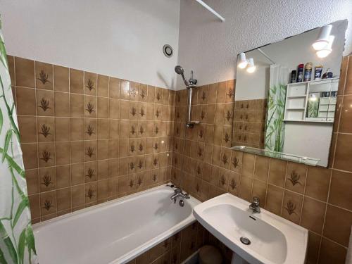 une salle de bain avec une baignoire, un lavabo et un miroir dans l'établissement Appartement 4 pers avec vue mer proche plage, animaux et parking inclus - FR-1-387-85, à Marseillan