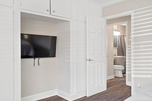 - une chambre dotée d'une télévision à écran plat sur un mur blanc dans l'établissement Wills off Wilton Drive 2 bed and 1 bath plus Den with Heated Pool, à Fort Lauderdale