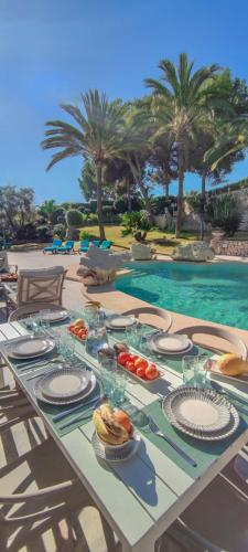 a table with food on it next to a swimming pool at Azzurra Home-Charming Property- For 6 guests in Benissa