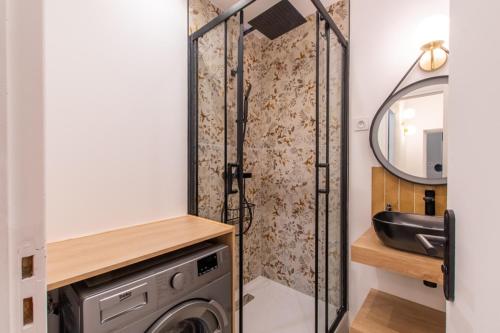 a bathroom with a washing machine and a mirror at Hirondelle de Montpellier in Montpellier