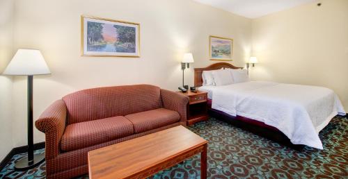 Habitación de hotel con cama y sofá en Hampton Inn Spartanburg Hotel, en Spartanburg
