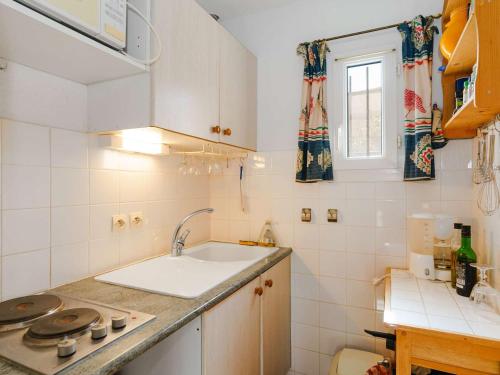 a small white kitchen with a sink and a window at Villa Gruissan, 3 pièces, 4 personnes - FR-1-409-31 in Gruissan