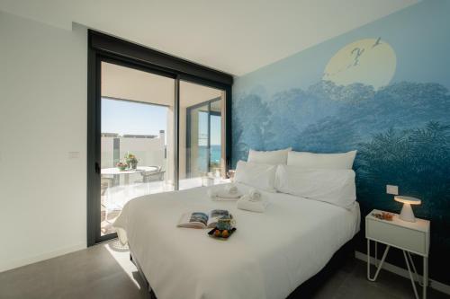 a bedroom with a large white bed and a large window at Horizonte Line in Villajoyosa