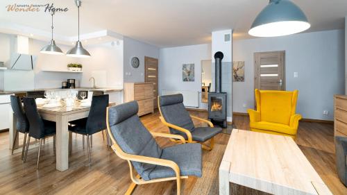 a kitchen and living room with a table and chairs at Wonder Home - Domki górskie z kominkami, bezpłatnym parkingiem i placem zabaw na terenie kompleksu in Karpacz