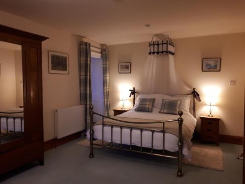 a bedroom with a bed with a canopy at The Old Convent Holiday Apartments in Fort Augustus