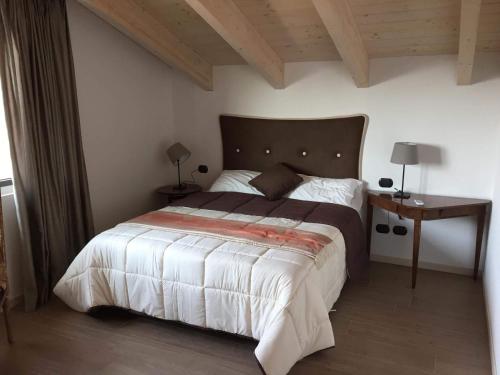 sypialnia z dużym łóżkiem i drewnianym sufitem w obiekcie La Villa Bianca Guest house w mieście Cantù