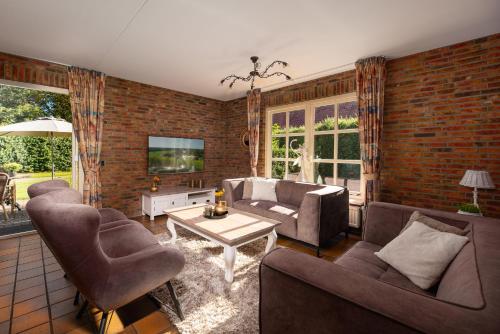 a living room with a couch and chairs and a table at 't Borghuis in Losser