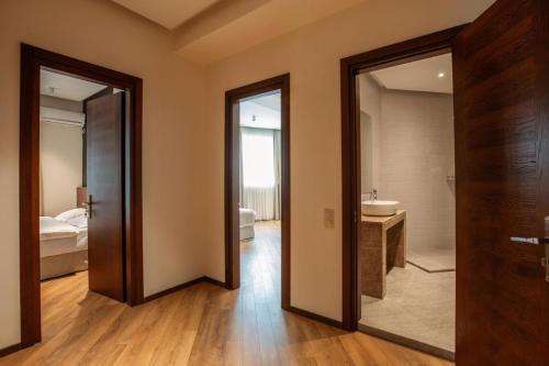 een kamer met een badkamer met een wastafel en een spiegel bij Nina Palace Hotel in Tbilisi City
