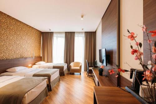 ein Hotelzimmer mit 2 Betten und einem TV in der Unterkunft Nina Palace Hotel in Tbilisi City
