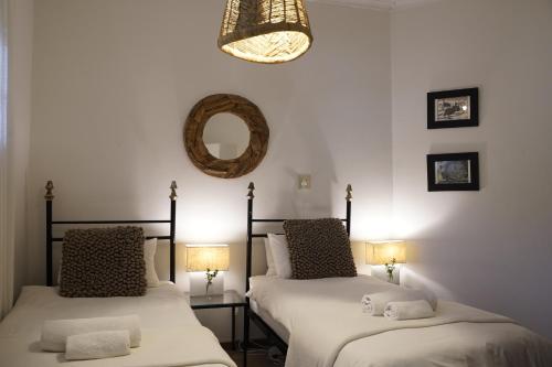two beds in a room with a mirror and two lamps at ALLURING SELF CATERING 2 BEDROOM VILLA at BOKMAKIERIE VILLAS in Windhoek