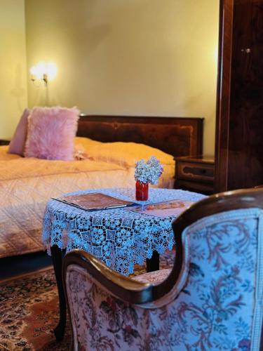 a room with a table and a bed and a table with flowers at Öreg Prés Butikhotel in Mór