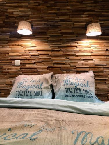 2 almohadas en una cama en una habitación con pared de madera en La Vie sur mer - appartement zijdelings zeezicht Mariakerke, en Ostende