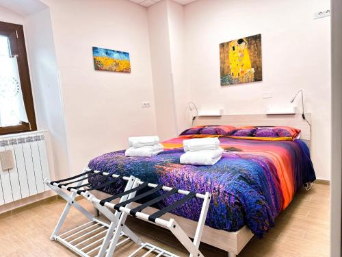 a bedroom with a bed with a colorful blanket at A Casa di Chicchi in Ovindoli