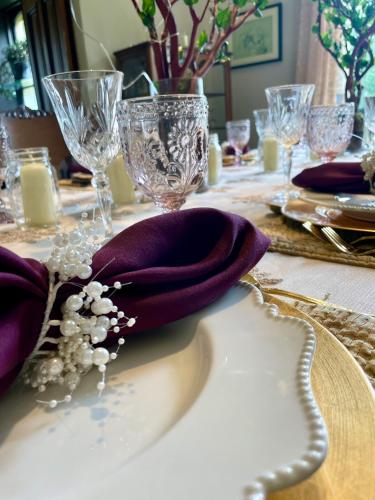 a table with a purple napkin and glasses on it at Norfolk Guest House Inn in Guelph