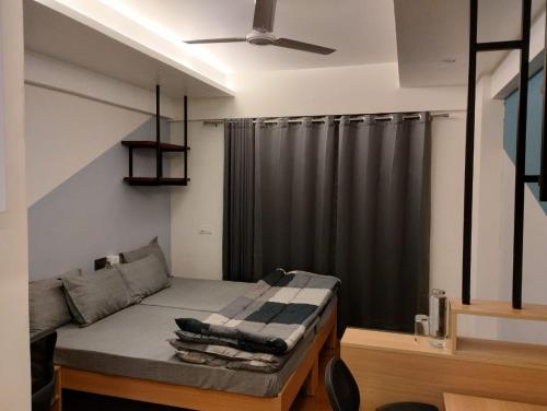 a bedroom with a bed with a black curtain at Ivy League House, Pyramid Residency in New Delhi