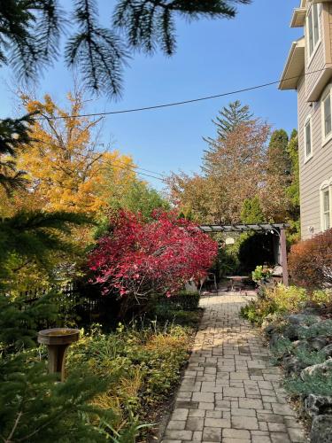 a garden with a brick walkway next to a house at Norfolk Guest House Inn in Guelph