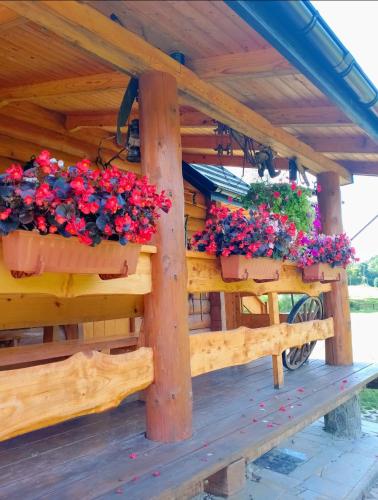 a wooden gazebo with two flower boxes on it at Siedlisko Sielska Dolina Nad Stawem luksusowy domek całoroczny z klimatyzacją in Tarnowiec