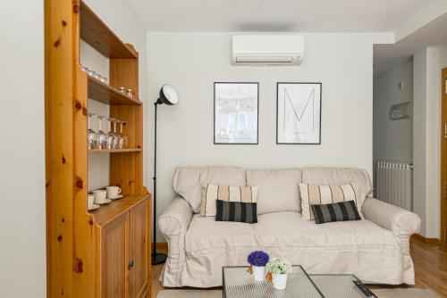 a living room with a white couch and a table at 2BR Av América Bernabeu Stadium in Madrid