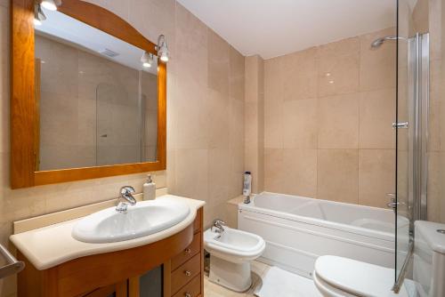 a bathroom with a sink and a toilet and a tub at 2BR Av América Bernabeu Stadium in Madrid