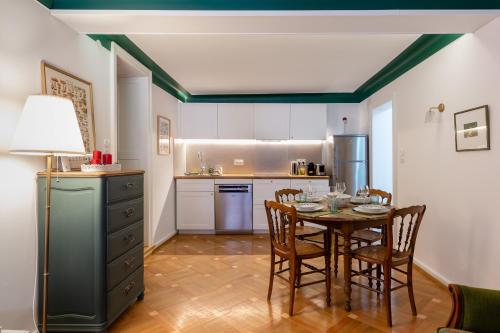 une cuisine avec une table et des chaises dans une pièce dans l'établissement Chabi Cottage Gîte au coeur d'Eguisheim, à Eguisheim