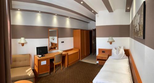 a small hotel room with a bed and a desk at Öreg Prés Butikhotel in Mór