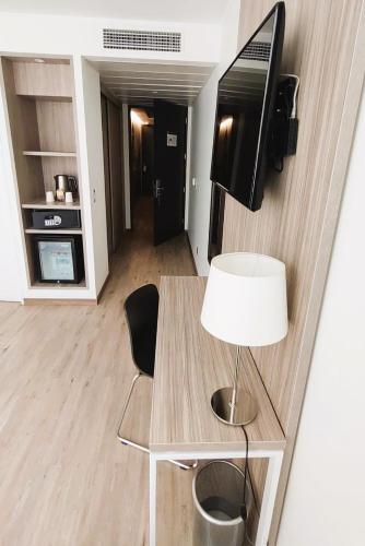 a living room with a table with a lamp and a television at Hotel Capital Bellet in Santiago
