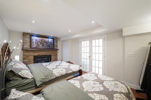 a bedroom with two beds and a fireplace at Cozy Lovely Ravine facing Suite. in Mississauga