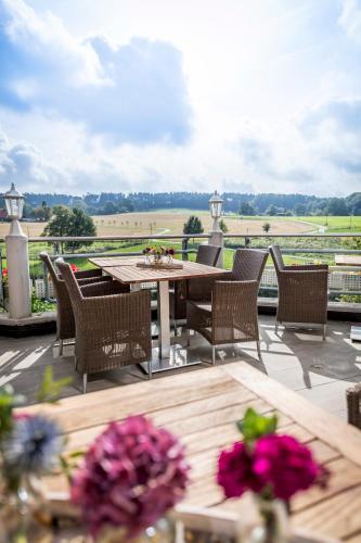 a patio with tables and chairs and a view of a field at Landhotel Buller in Hagen
