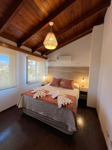 a bedroom with a large bed with a wooden ceiling at Uptown City Apart La Falda in La Falda