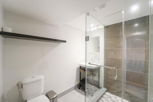 a bathroom with a toilet and a glass shower at Cozy Lovely Ravine facing Suite. in Mississauga