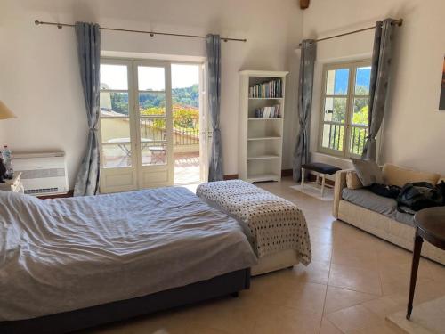 um quarto com uma cama, um sofá e uma janela em Villa vue mer à côté de Cannes dans l'Esterel ! em LʼÉglise